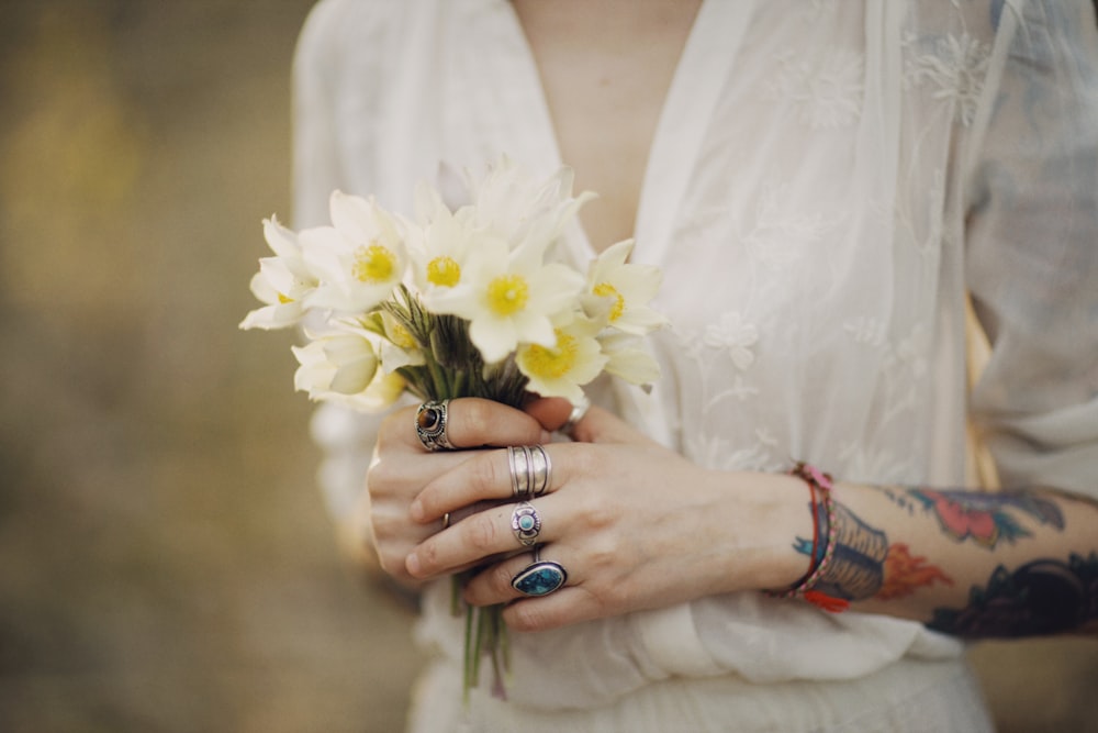白い花を持つ白いドレスの女性