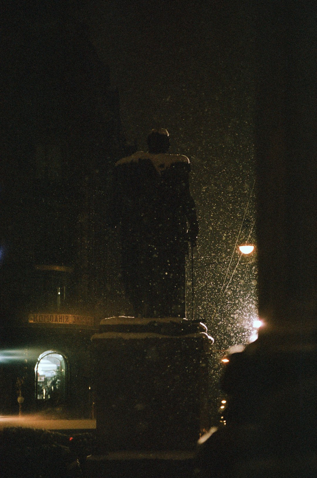 man in black jacket standing near car during night time
