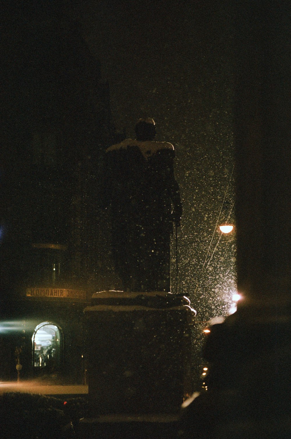 man in black jacket standing near car during night time