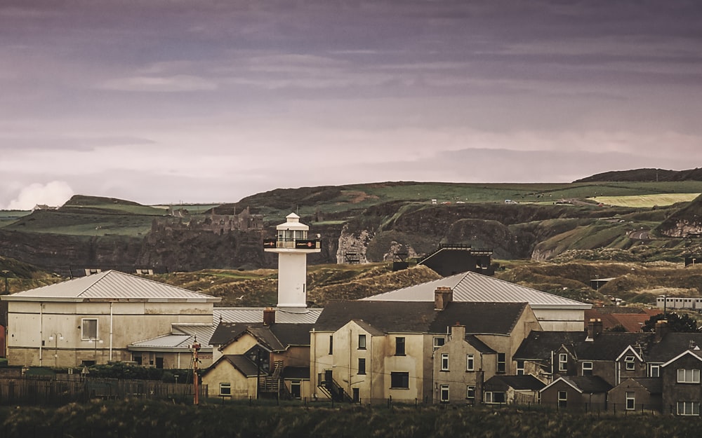 Maisons en béton blanc et brun sous ciel gris pendant la journée