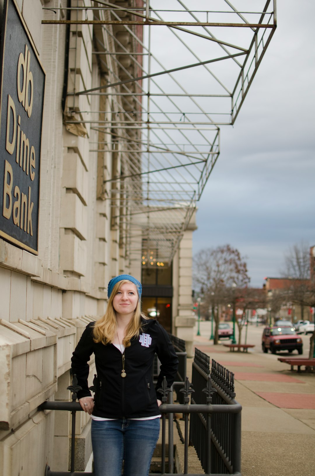 woman in black jacket standing near building during daytime