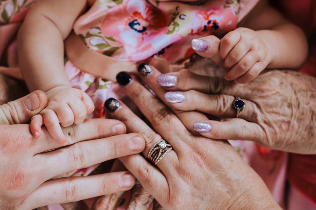 person wearing silver ring with red and white nail polish