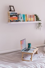 A cozy reading corner with shelves full of Islamic books and a laptop showing an online lecture.