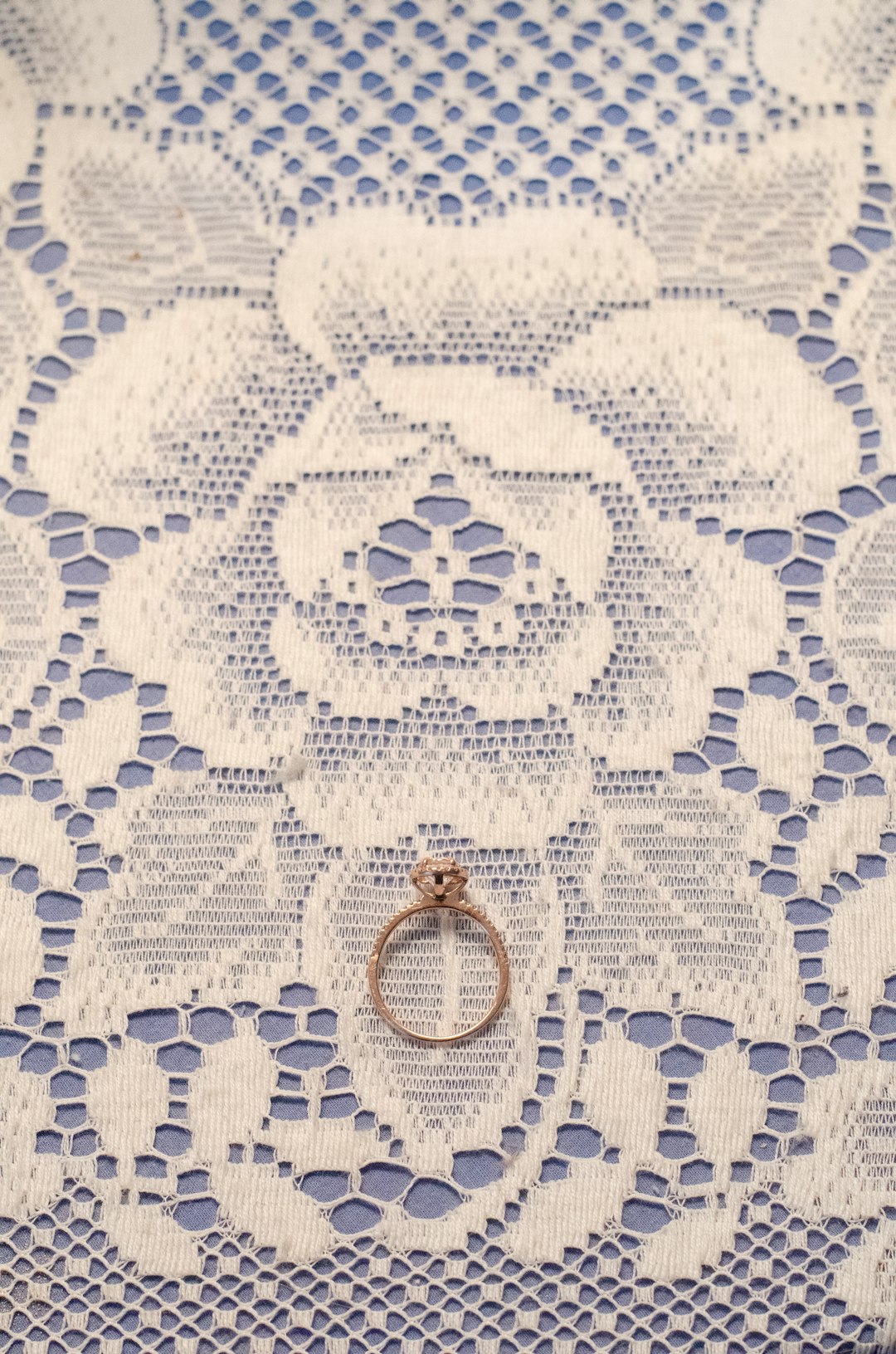 gold ring on white and blue floral textile