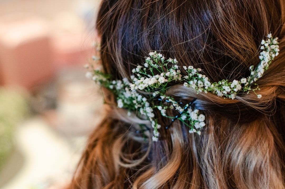 woman with brown hair wearing white flower headband