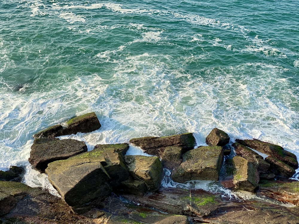 brown rocks near body of water during daytime