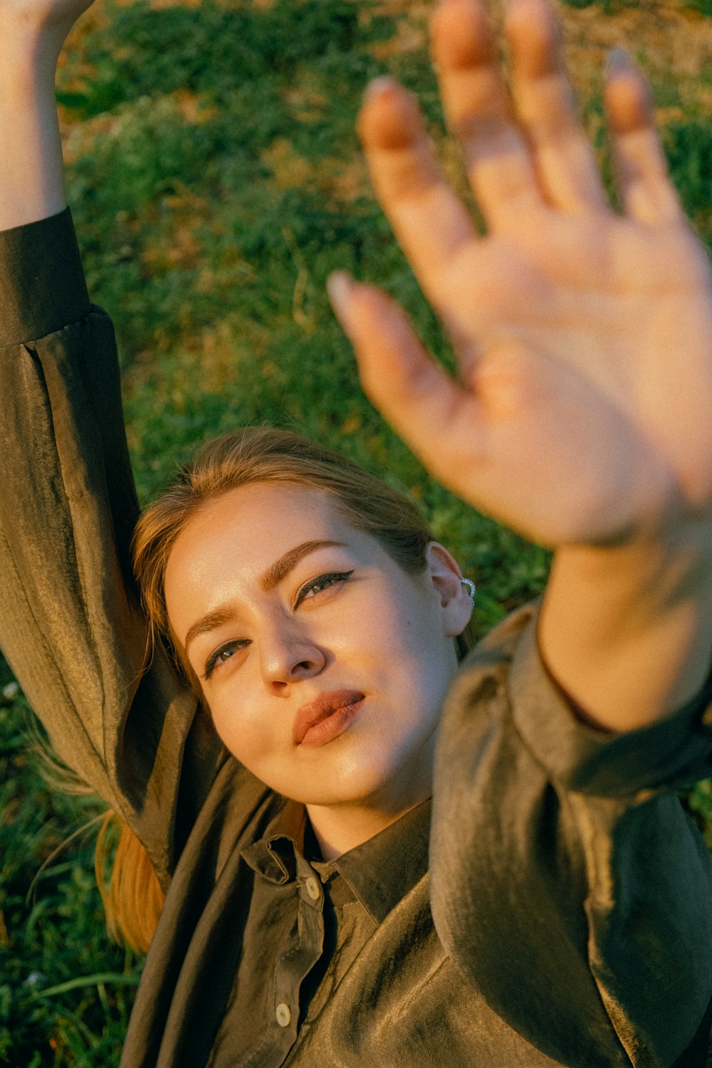 girl in green jacket lying on brown wooden swing during daytime