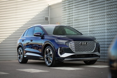 Front view of a sleek dark blue Hyundai SUV parked in a modern urban setting.