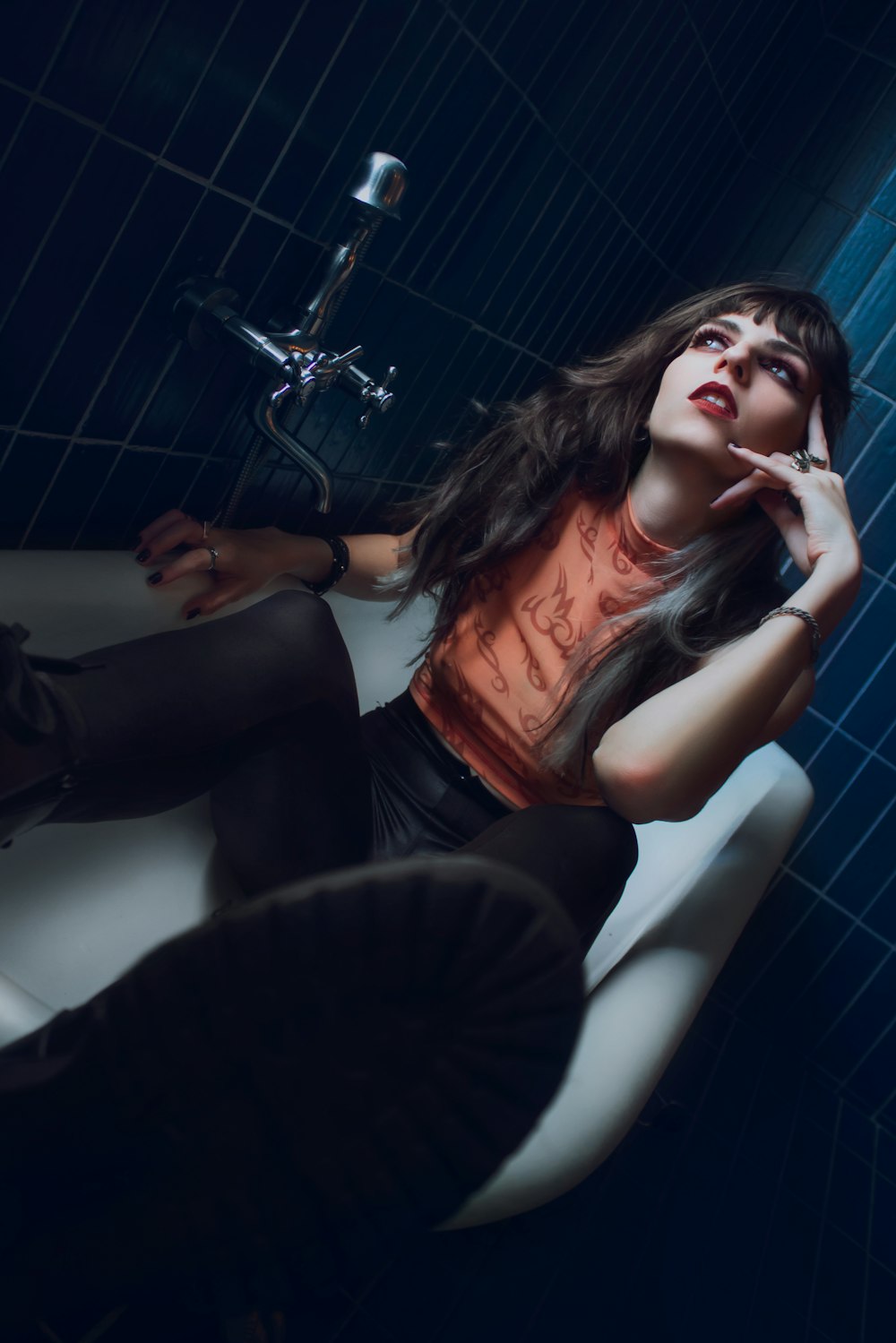 woman in black long sleeve shirt sitting on white ceramic bathtub