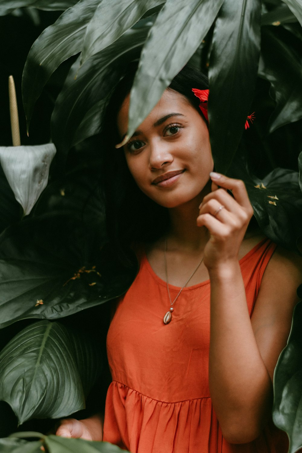 woman in orange shirt wearing silver necklace