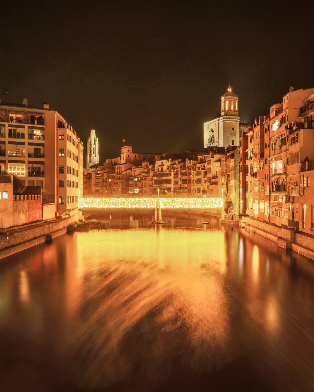 brown concrete building near river during night time