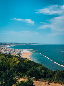 A panoramic view of Gran Canaria's coastline with turquoise waters and golden sandy beaches under a bright blue sky.