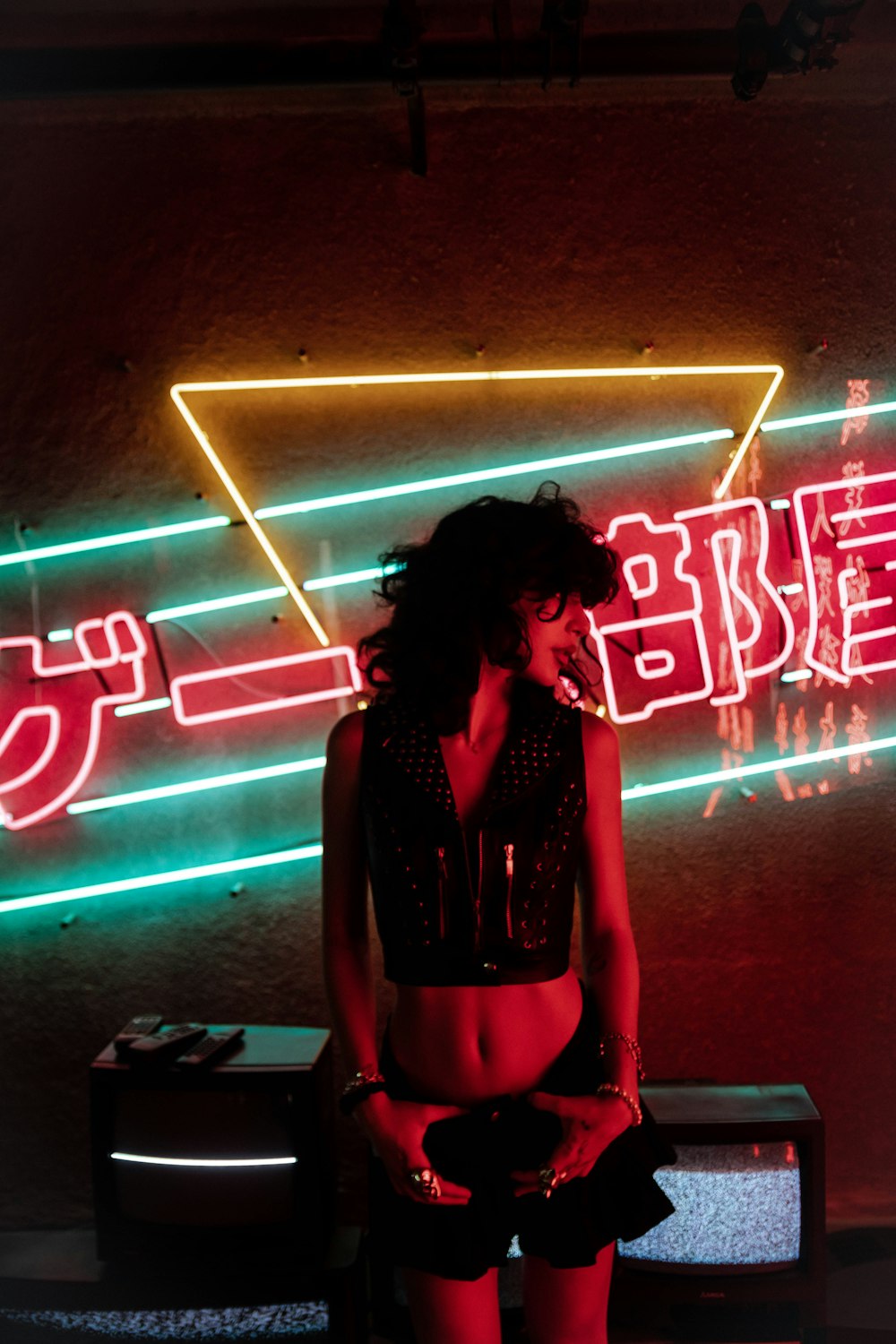woman in black long sleeve shirt standing in front of neon light signage