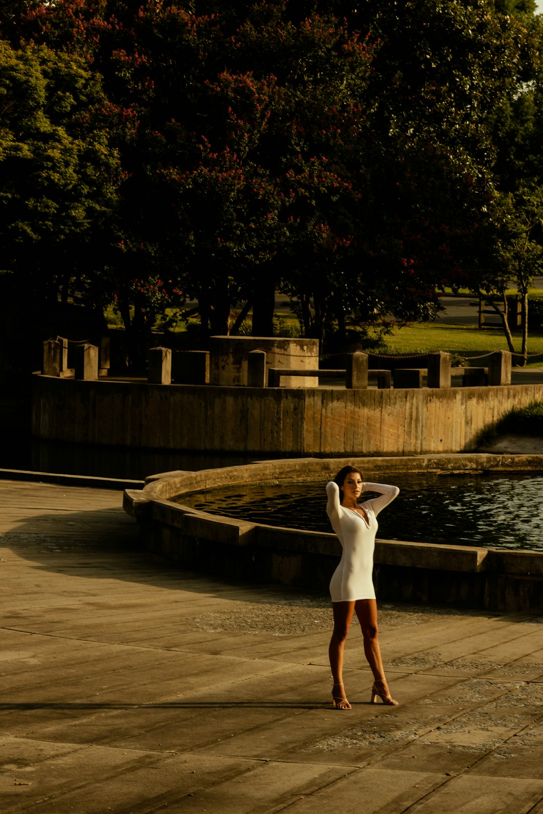 woman in white dress standing on brown concrete floor during night time