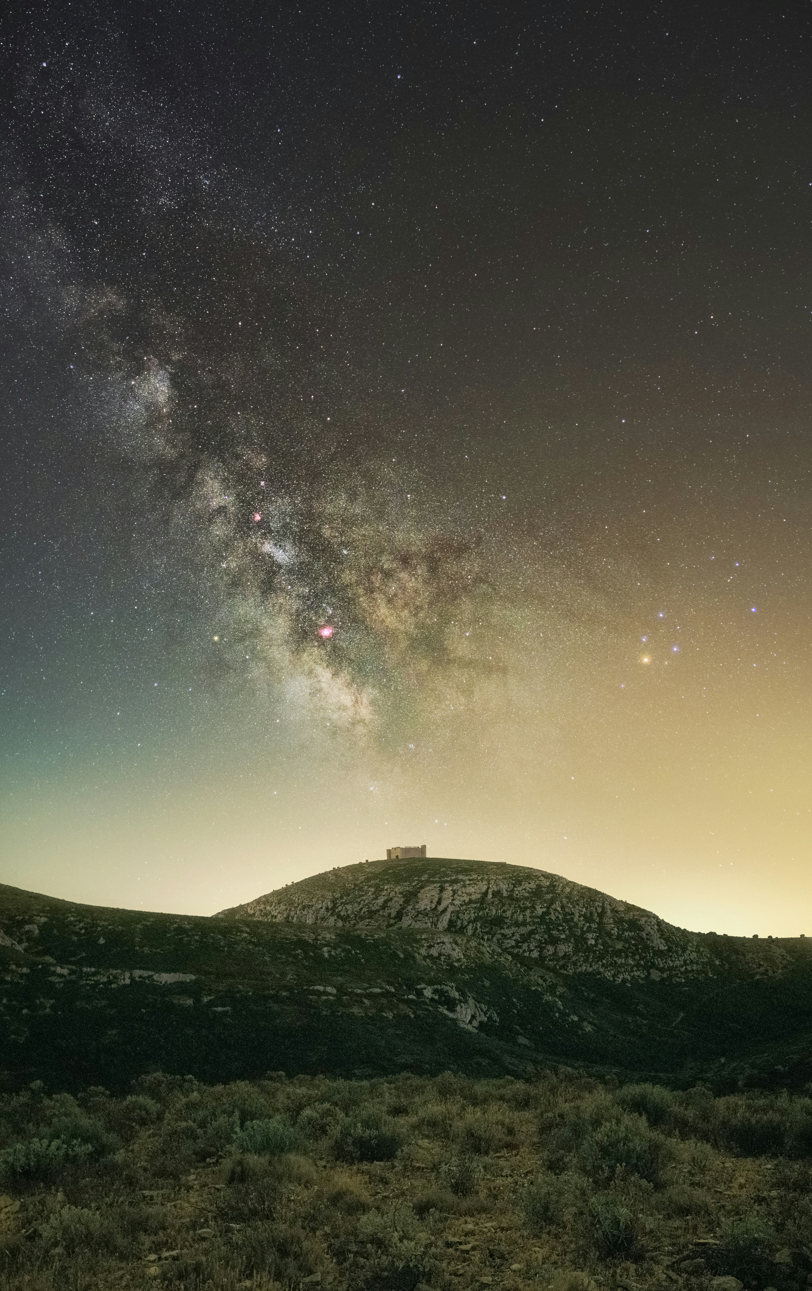 silhouette of house on hill under starry night