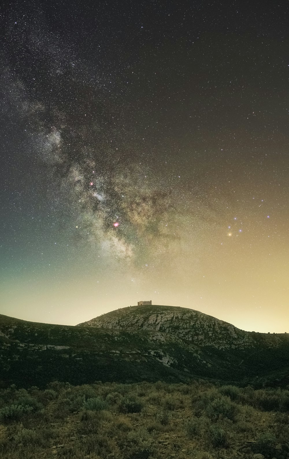 silhouette of house on hill under starry night