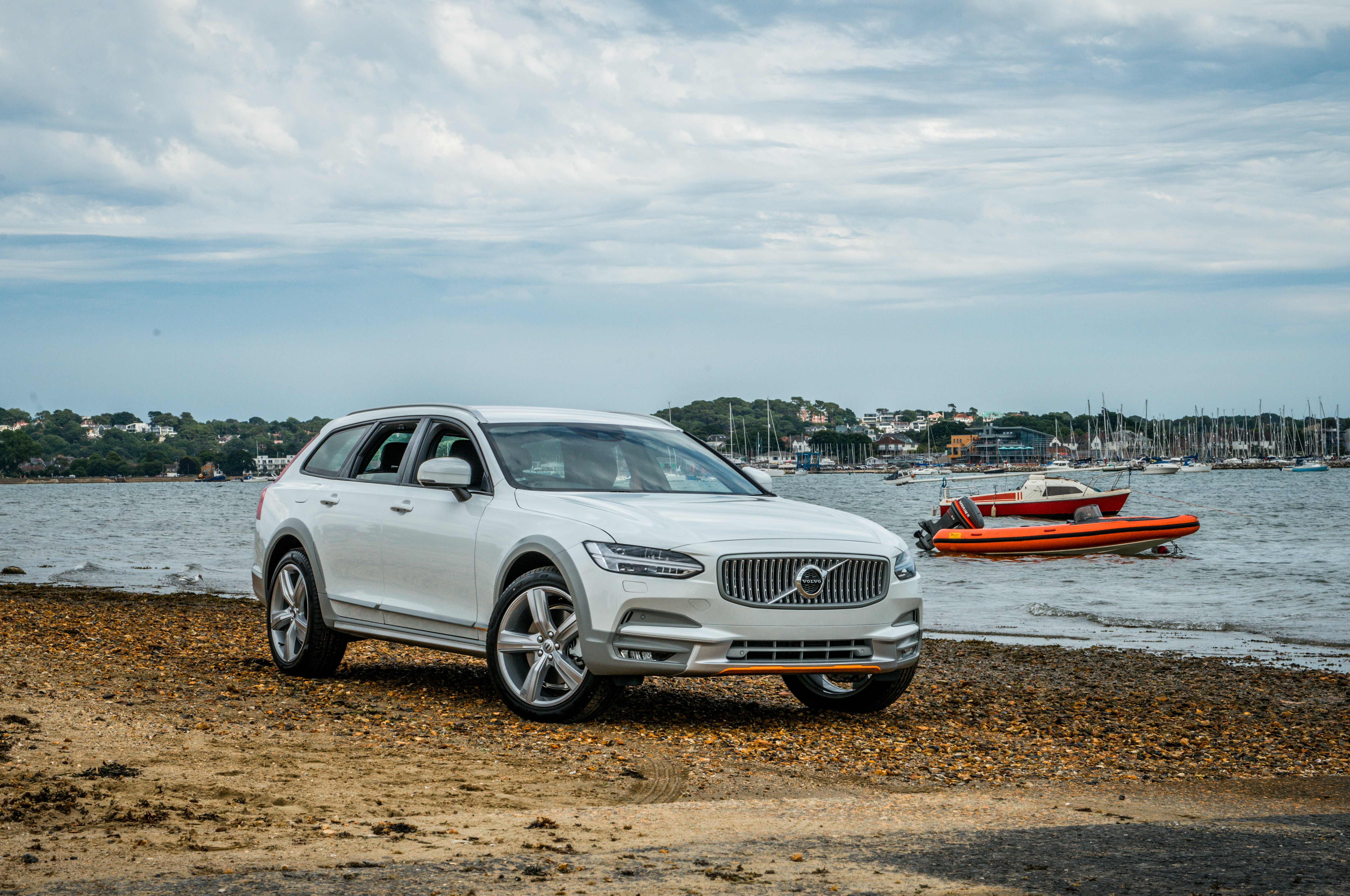Silber Audi A 4 auf braunem Sand in der Nähe von Gewässern tagsüber