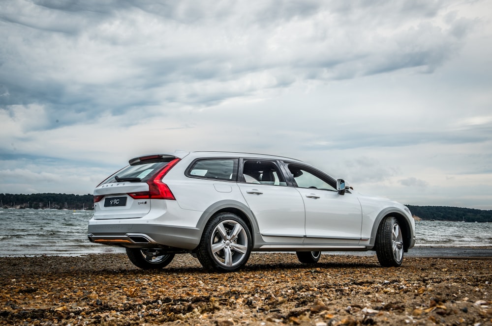 silver sedan on brown soil under white clouds during daytime