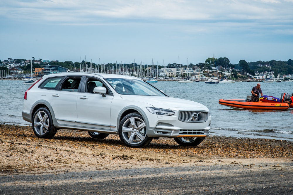 silver mercedes benz sedan parked near body of water during daytime