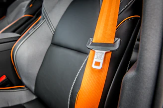 orange and white belt on black leather seat