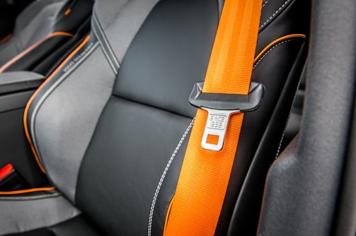 orange and white belt on black leather seat