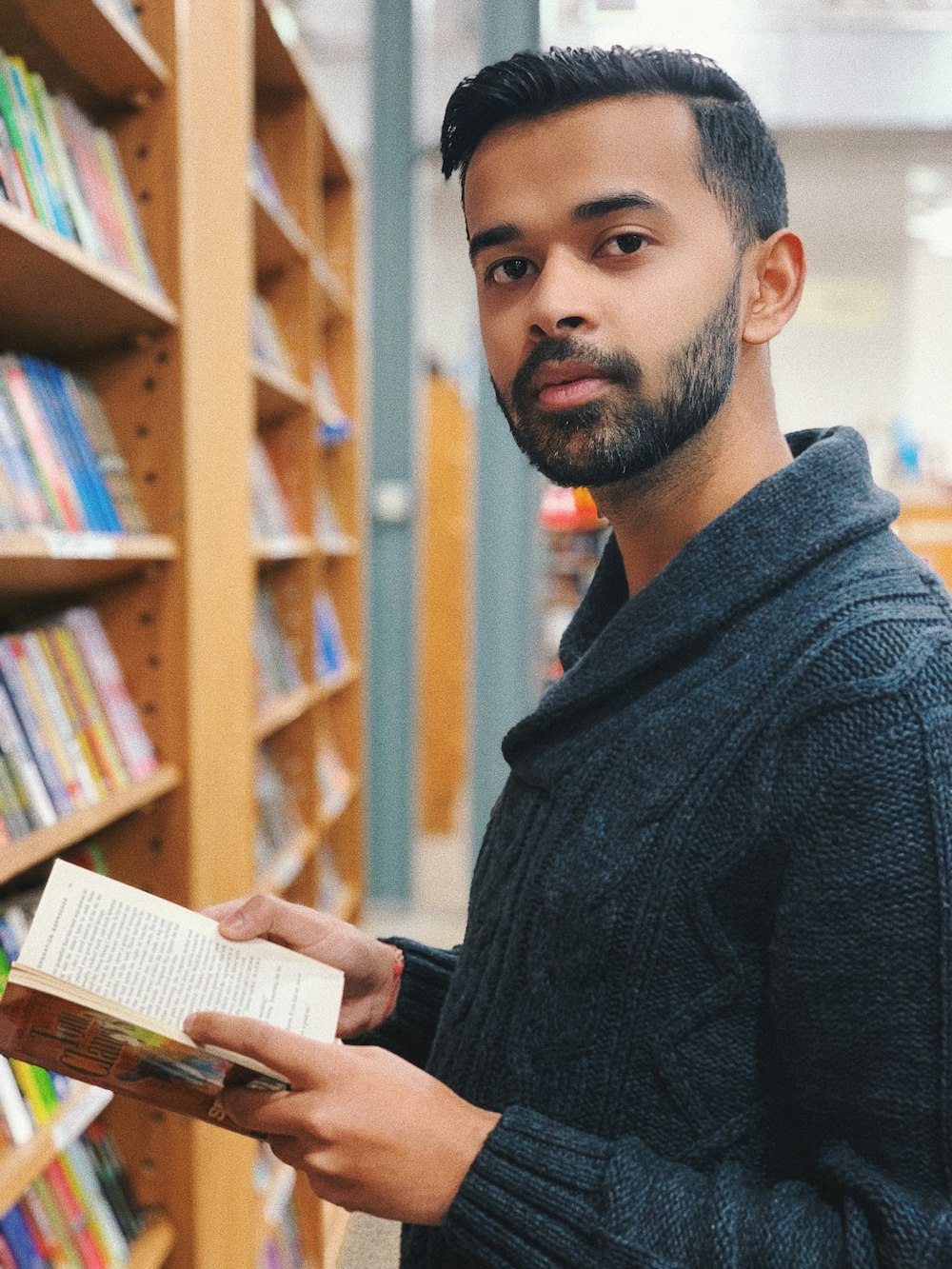 man in black sweater reading book