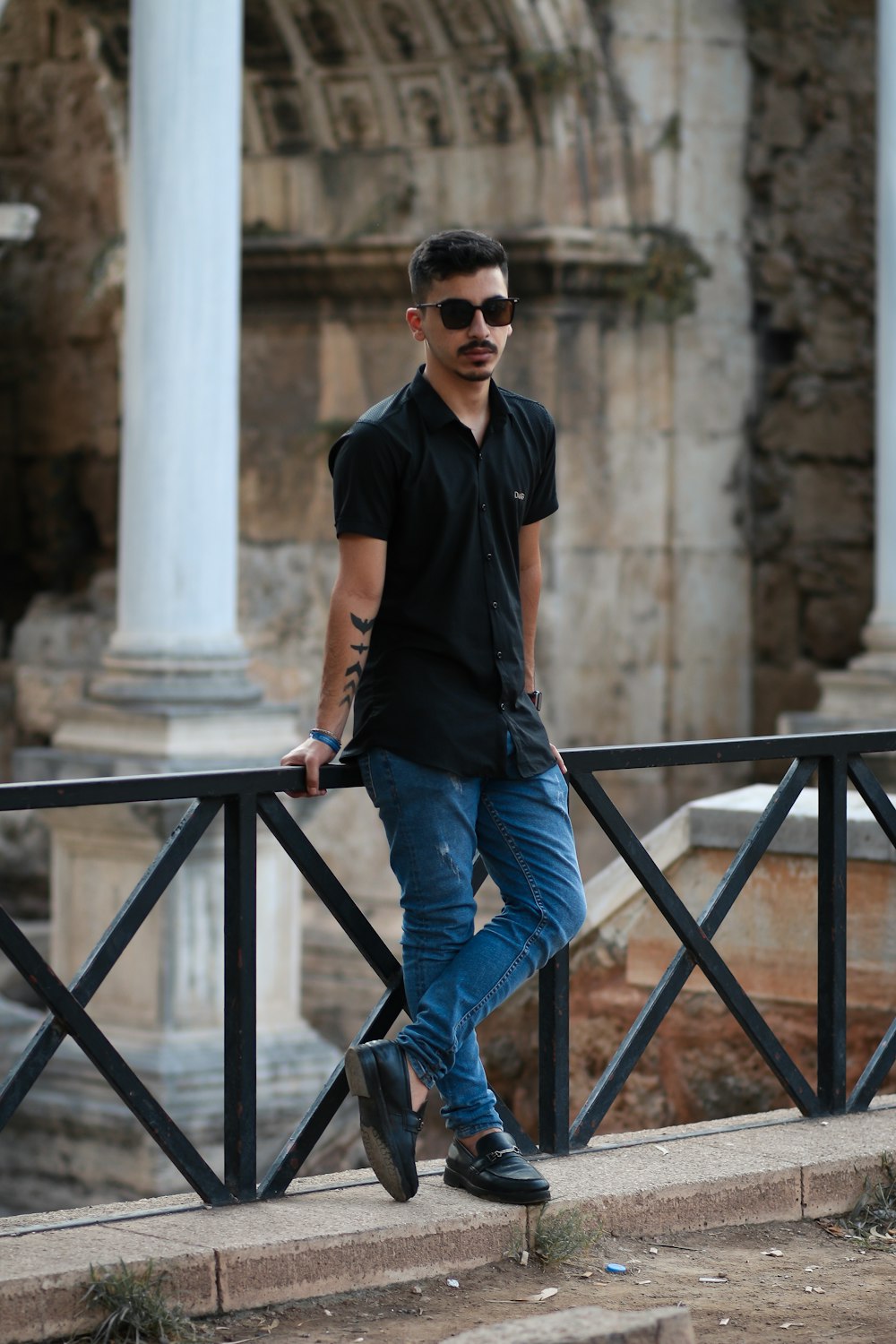 Man in black crew neck t-shirt and blue denim jeans standing on gray  concrete stairs photo – Free Clothing Image on Unsplash