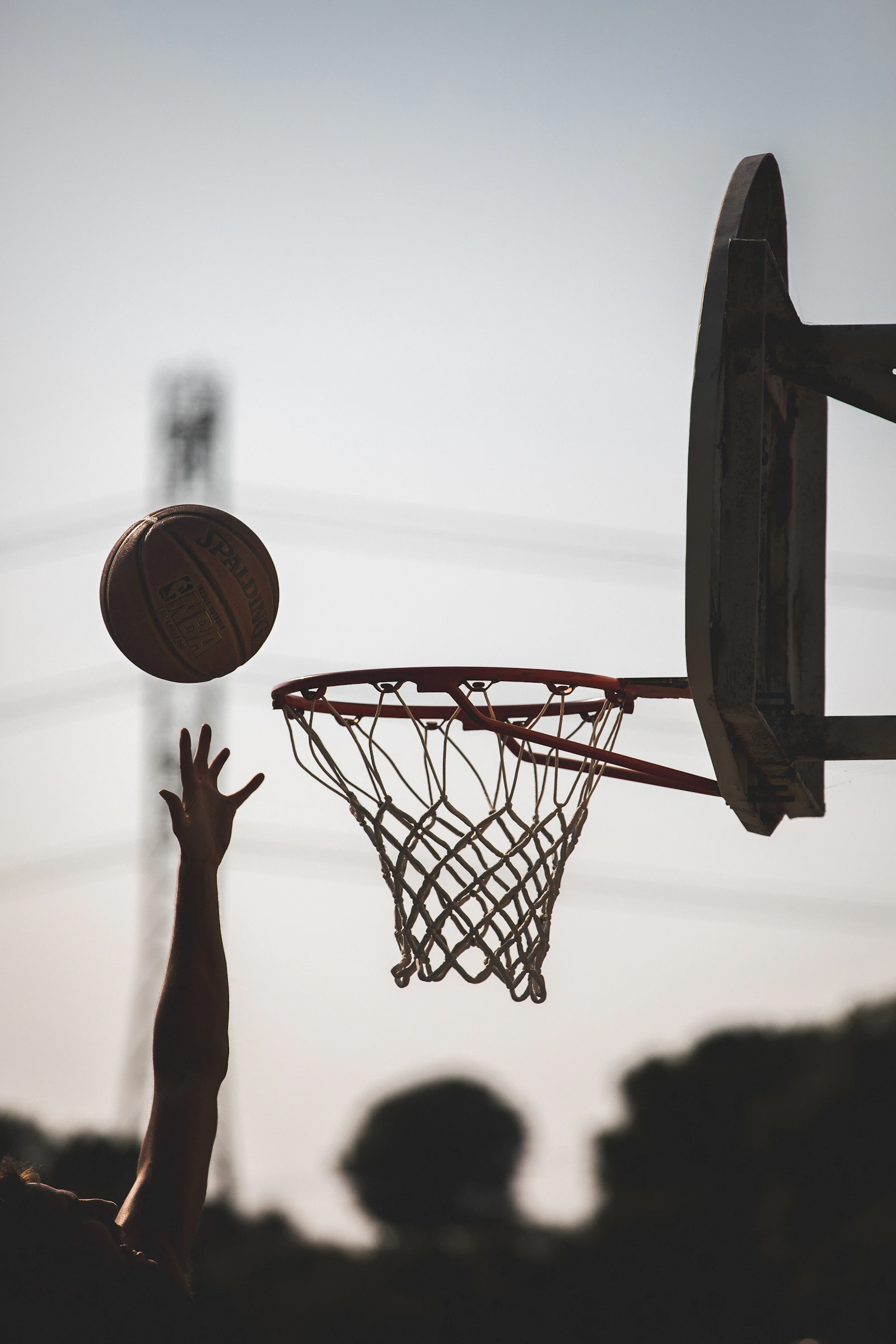 A weathered outdoor basketball hoop against an open sky
