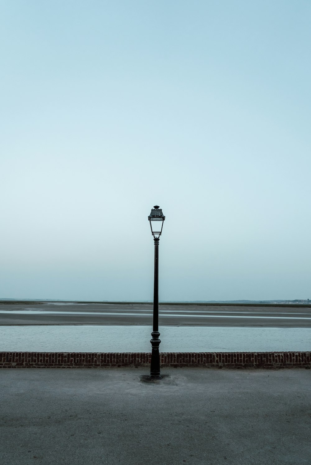 black street lamp on brown wooden dock during daytime