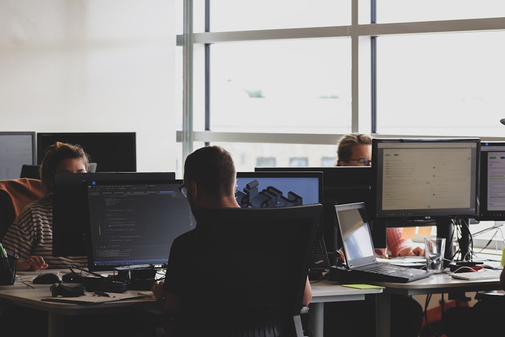 pessoas sentadas na cadeira na frente do monitor do computador