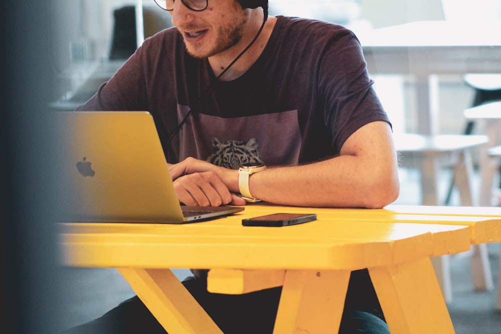 Mann in Schwarz Rundhals-T-Shirt mit silbernem MacBook