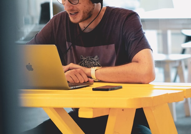 man in black crew neck t-shirt using silver macbook