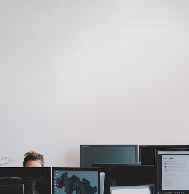 man in black jacket sitting beside black flat screen computer monitor