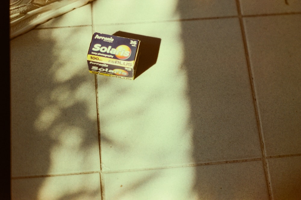 Boîte bleue et blanche sur carreaux de sol en céramique blanche