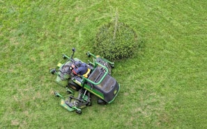 Operator controlling the remote mower safely from a distance on a rugged terrain
