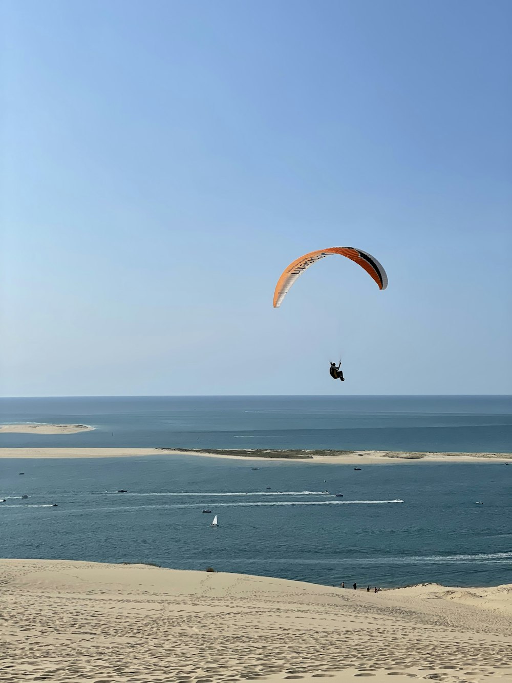 person in yellow parachute over the sea during daytime