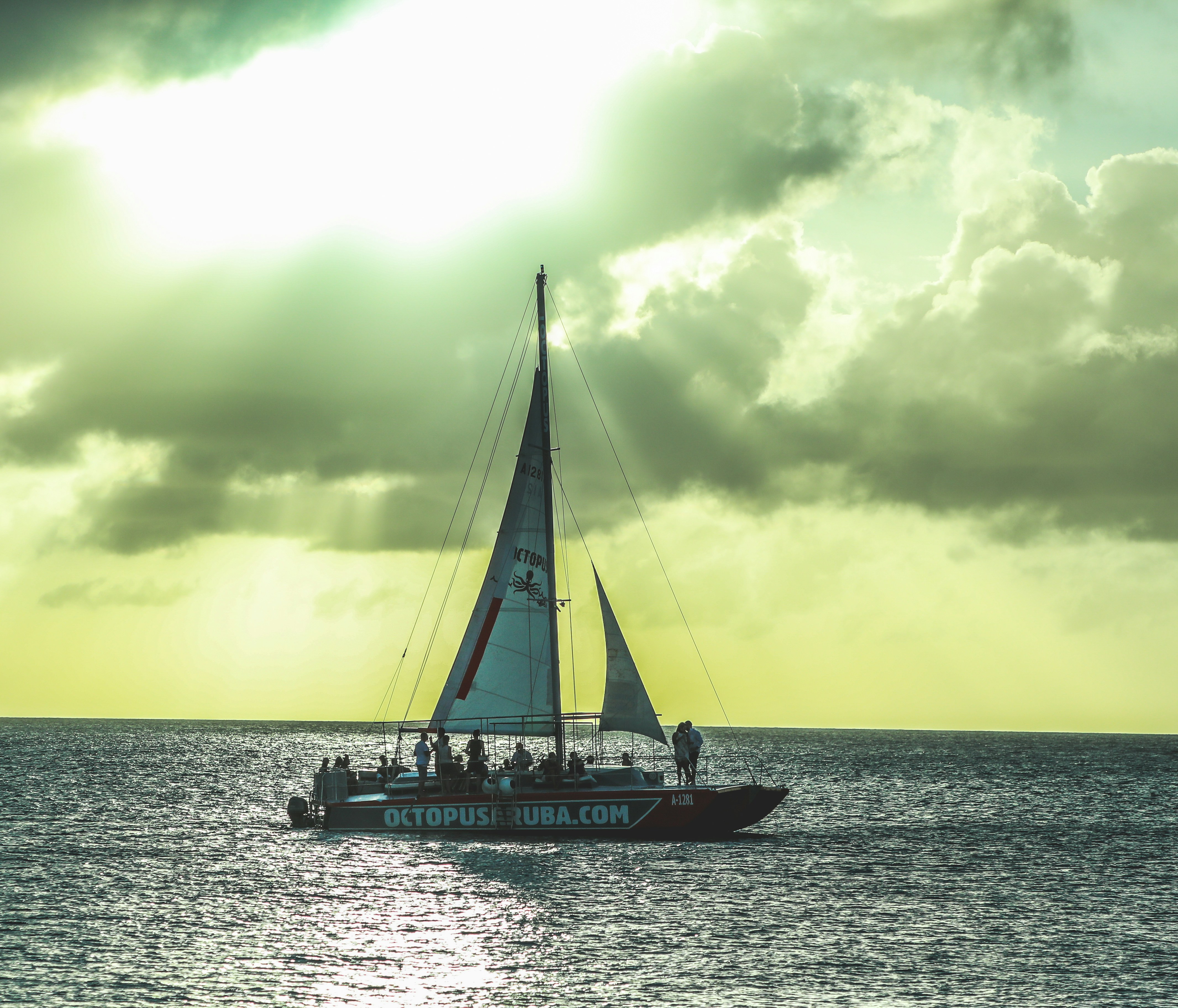 Weißes und blaues Boot auf See unter weißen Wolken