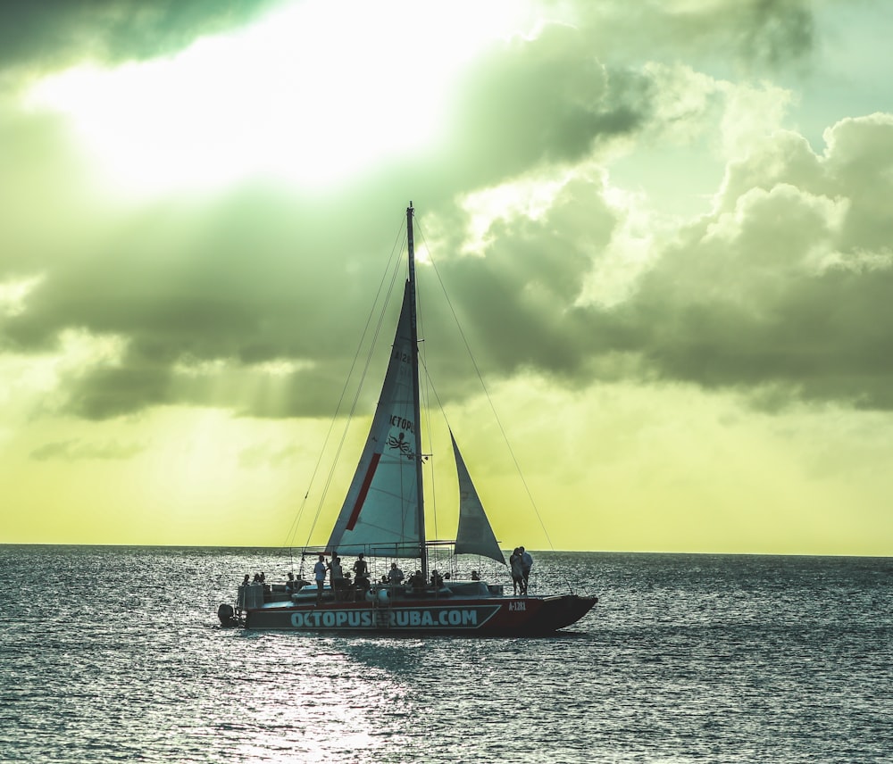 white and blue boat on sea under white clouds