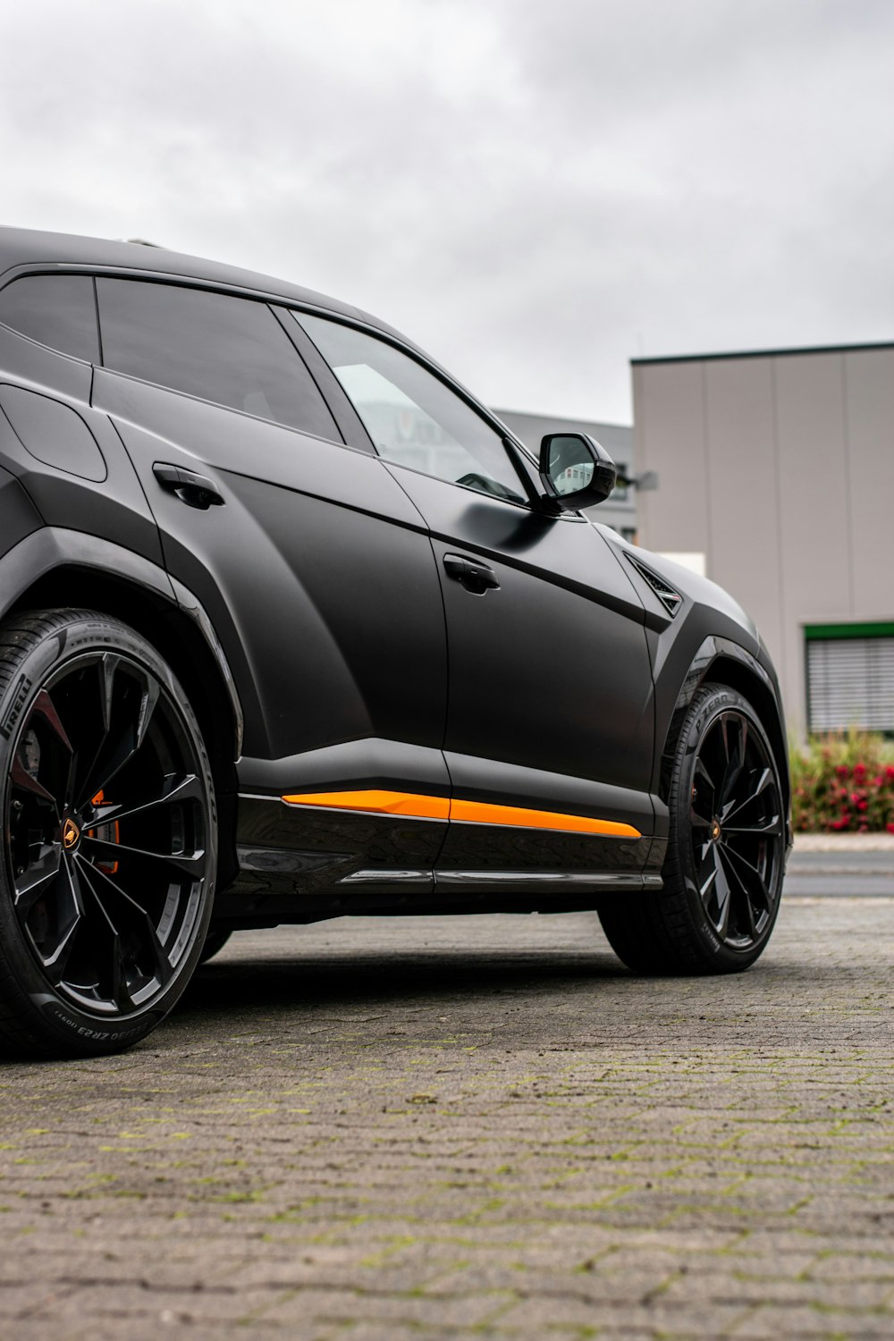 black and yellow coupe in front of white building