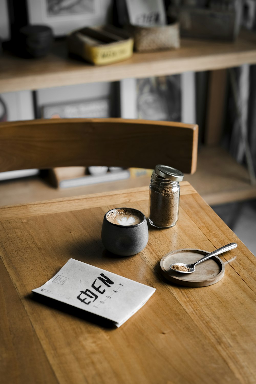 silver and black round watch beside white printer paper on brown wooden table