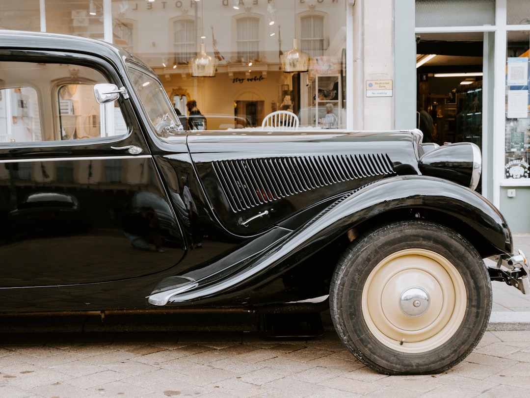 black classic car parked on sidewalk during daytime