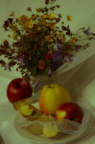 An elegant still life arrangement with flowers and fruits.