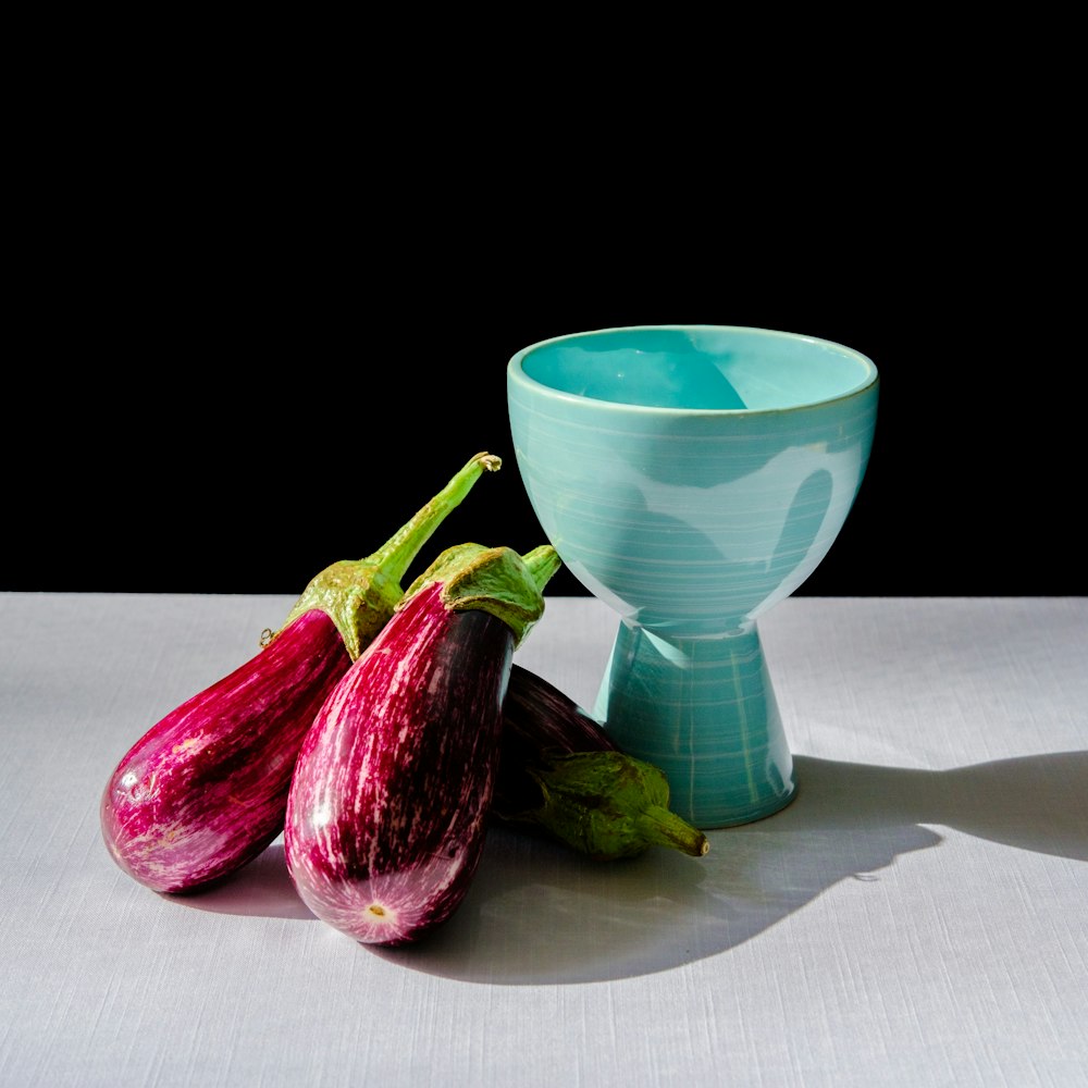 green ceramic cup beside purple vegetable