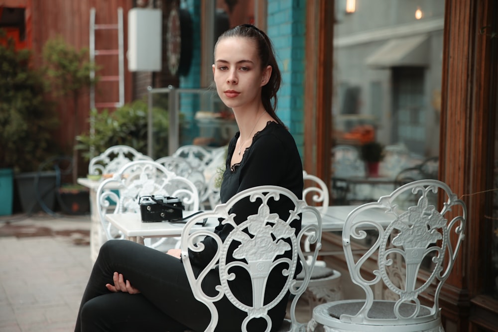 woman in black shirt sitting on white chair