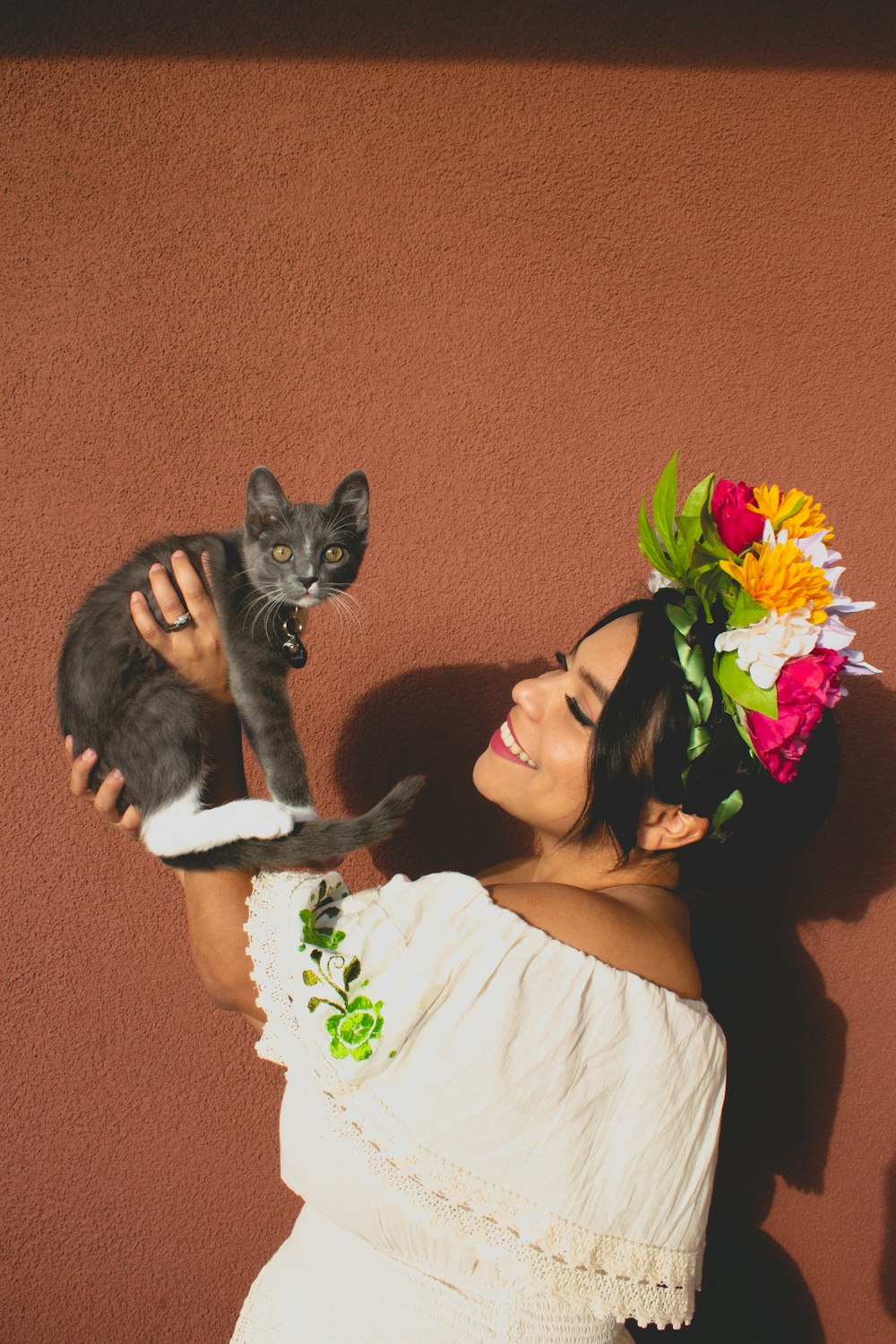 woman in white shirt holding black cat