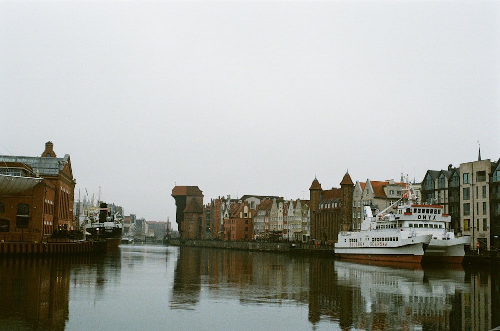 white boat on water near brown concrete building during daytime