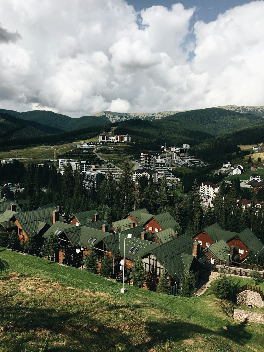 houses on green grass field under white cloudy sky during daytime