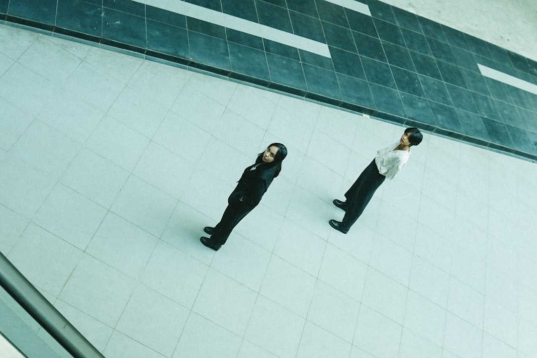 man in black suit jacket and black pants standing beside man in white dress shirt