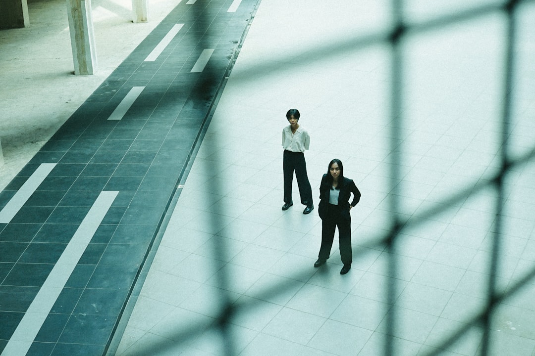 2 women walking on white floor tiles