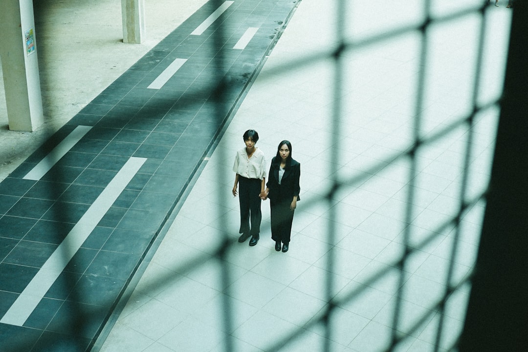 woman in white long sleeve shirt and black skirt standing on white floor tiles